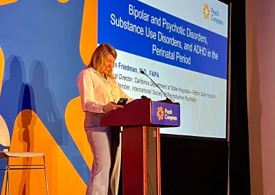 A woman speaking into a microphone at a conference.