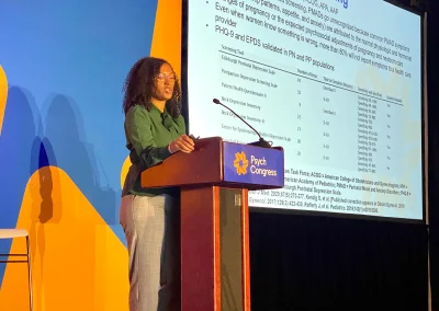 A woman giving a presentation at a conference.