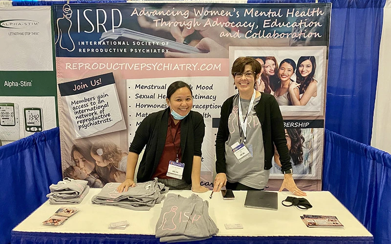 Two women running a booth at a conference